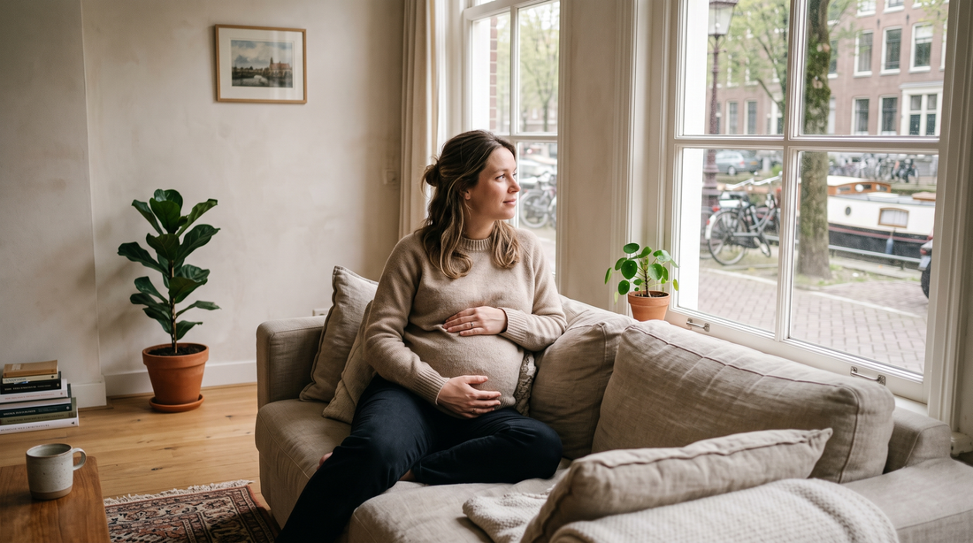 Zwangere vrouw zit rustig bij het raam
