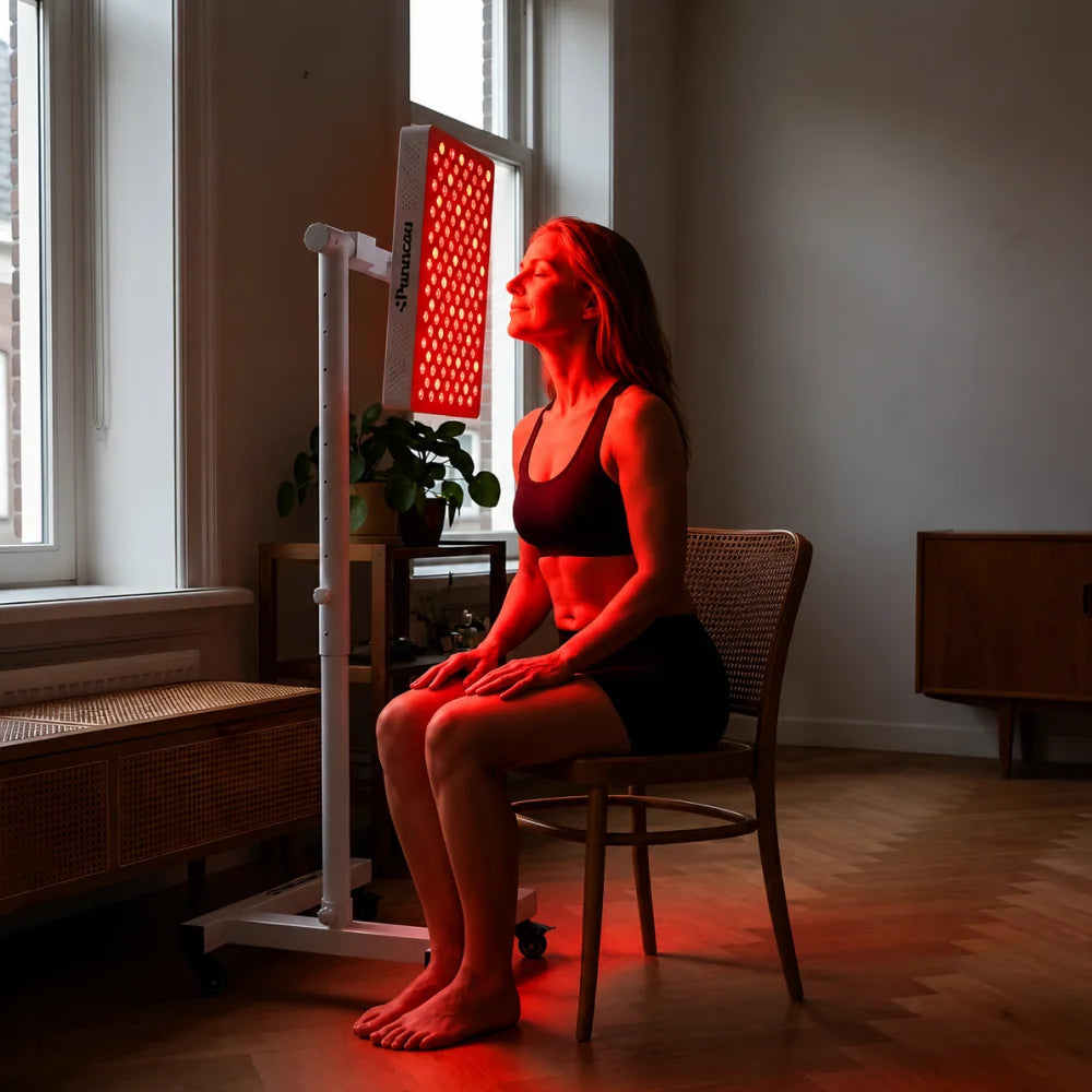 Vrouw zit op een stoel voor de ATP Pure 700 op de verrijdbare standaard bij het raam