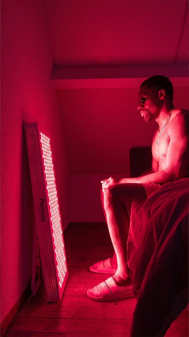 Man steht im roten Licht eines Panacea-Panels im Schlafzimmer.
