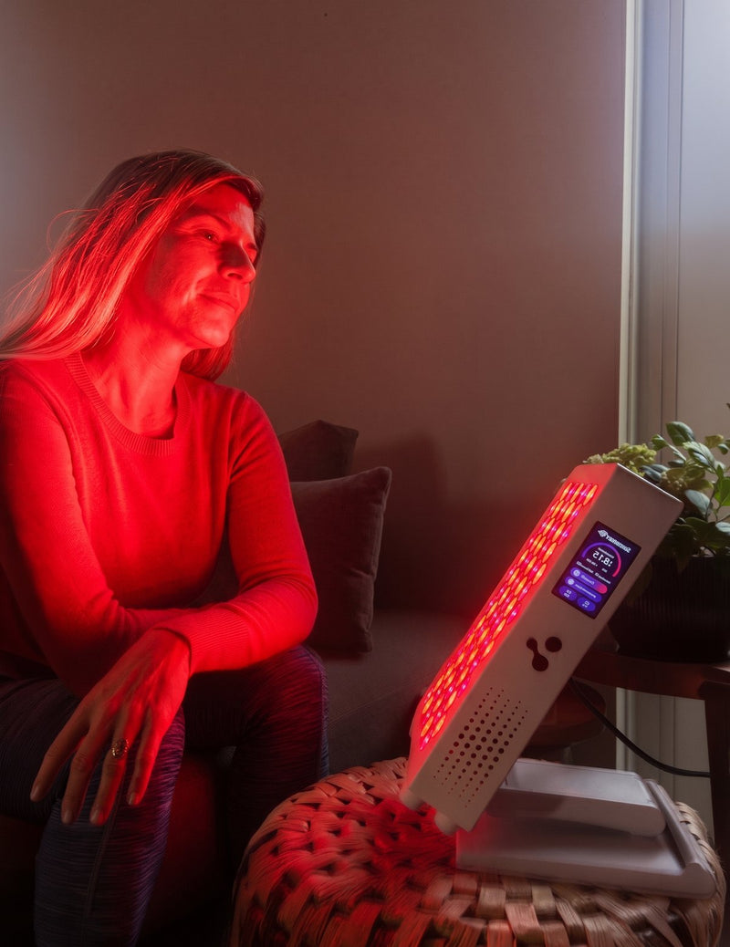 Eine Frau sitzt vor einem ATP Pro-Panel im roten Licht