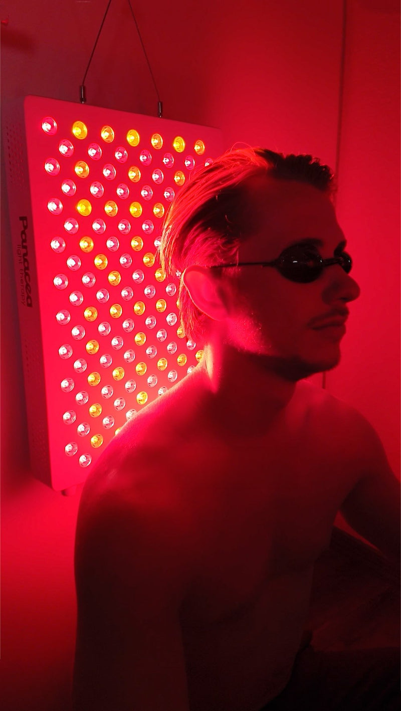 Mann mit Schutzbrille vor einem Panacea-Rotlichtpanel